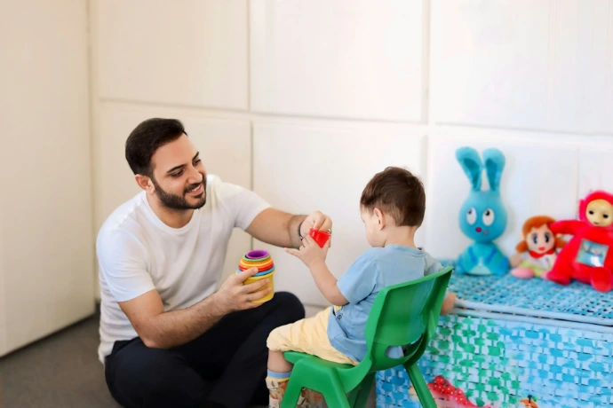 A man is playing with a child in a room